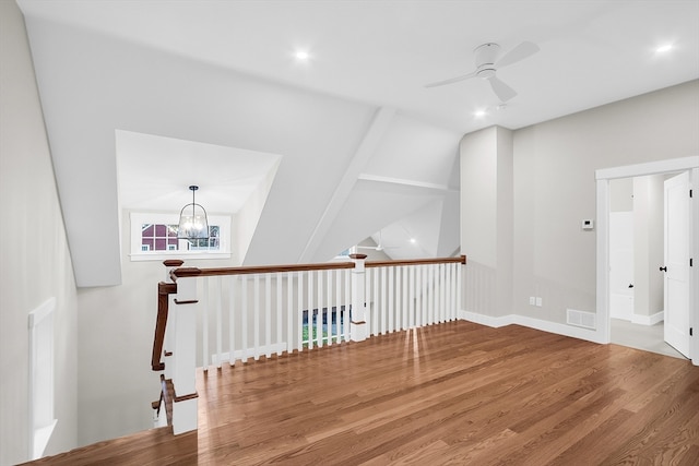 bonus room with hardwood / wood-style flooring and ceiling fan with notable chandelier