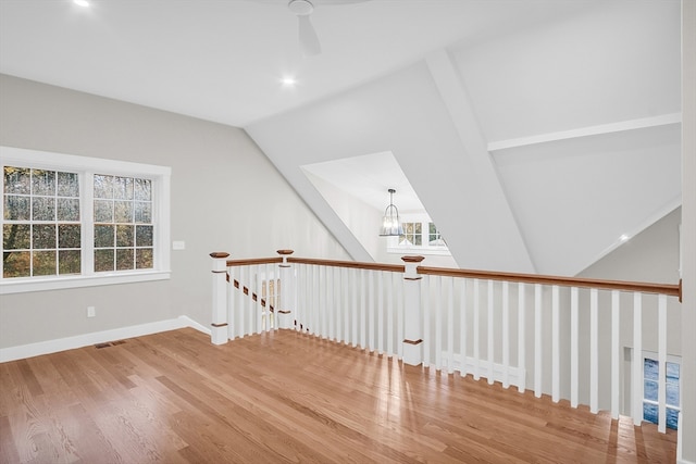 bonus room featuring hardwood / wood-style floors, a chandelier, and vaulted ceiling