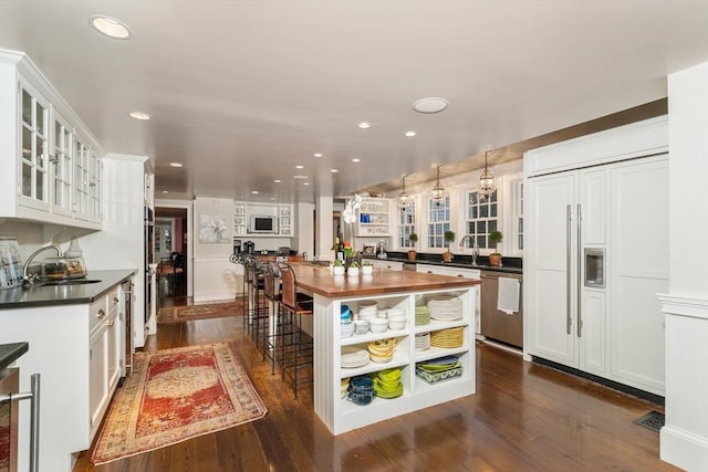 kitchen featuring white cabinets, open shelves, a sink, wooden counters, and stainless steel dishwasher