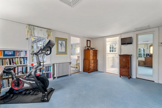 workout area with radiator, visible vents, and carpet floors