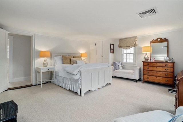 carpeted bedroom featuring visible vents and ornamental molding