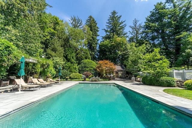 outdoor pool featuring a patio area and fence