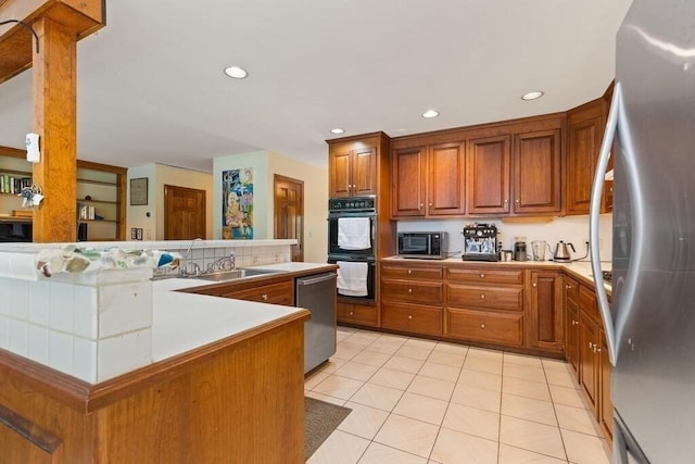 90 Southern Ave Unit 90, Essex, MA 01929 - kitchen featuring stainless steel appliances, a sink, brown cabinets, tile counters, and light tile patterned flooring