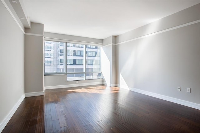 empty room with baseboards and wood finished floors