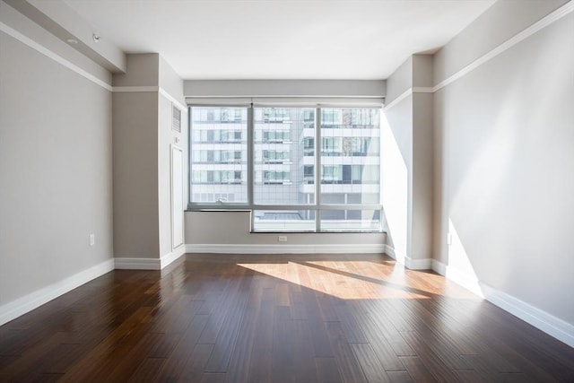 unfurnished room with baseboards and wood finished floors