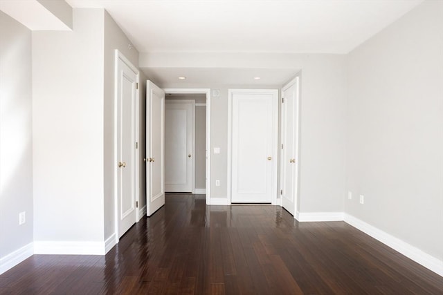 unfurnished bedroom with baseboards, recessed lighting, and dark wood-style floors