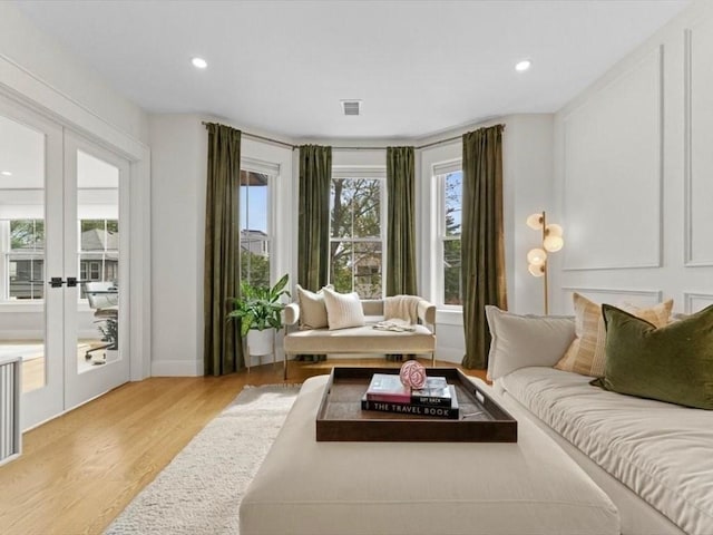 39 Paul St, Watertown, MA 02472 - living room with light wood-type flooring, recessed lighting, french doors, and baseboards