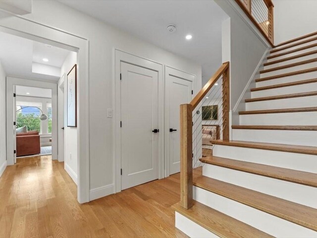 39 Paul St, Watertown, MA 02472 - stairway with wood finished floors, baseboards, and recessed lighting