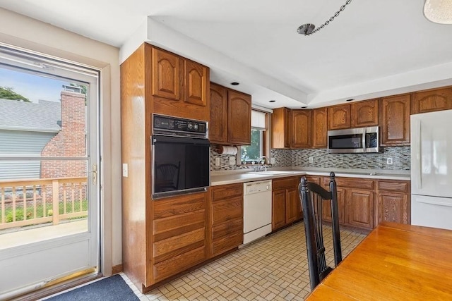 32 Cambo St, Brockton, MA 02301 - kitchen with white appliances, decorative backsplash, light countertops, and brown cabinets
