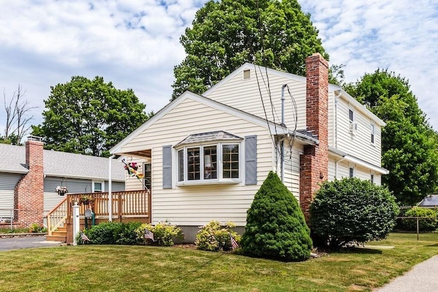 32 Cambo St, Brockton, MA 02301 - view of front of home with a front lawn, a wooden deck, and a chimney