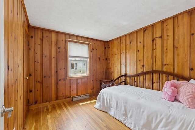 32 Cambo St, Brockton, MA 02301 - bedroom with a baseboard heating unit, light wood-style floors, and wooden walls