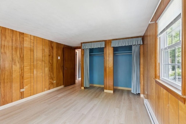 32 Cambo St, Brockton, MA 02301 - unfurnished bedroom with light wood-style flooring, wood walls, multiple closets, and baseboard heating