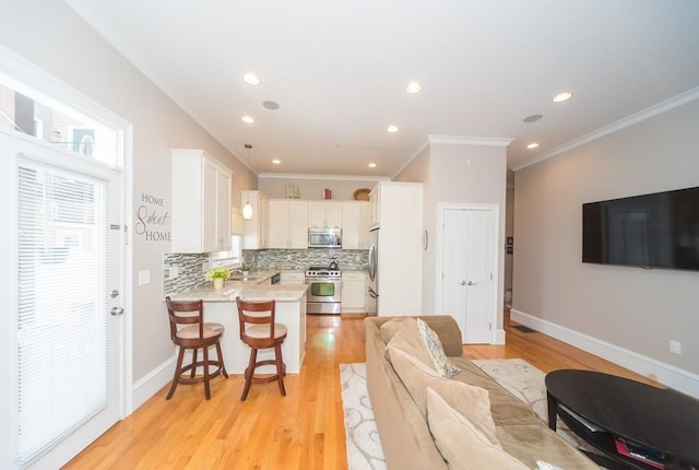 living room featuring crown molding, sink, and light wood-type flooring