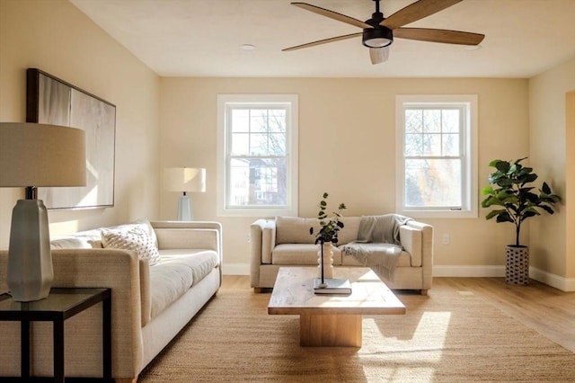 living area featuring a healthy amount of sunlight, ceiling fan, and light hardwood / wood-style flooring