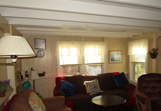 living room with beam ceiling and wooden walls