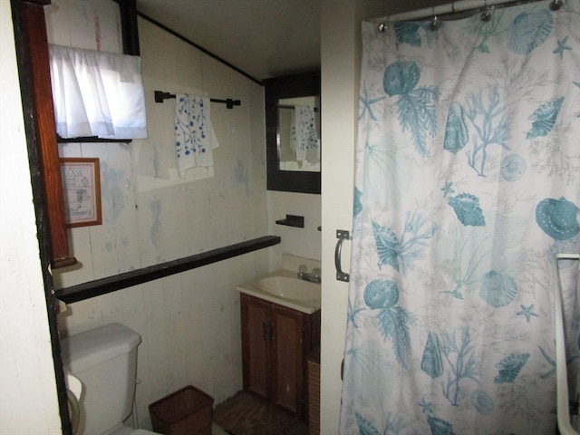 bathroom featuring vanity, toilet, and walk in shower