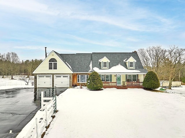 new england style home with a garage and covered porch