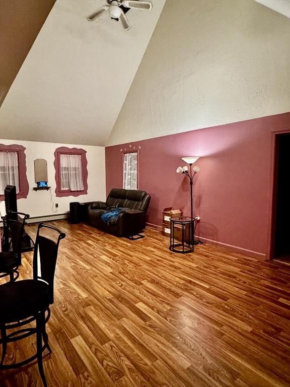 living room featuring ceiling fan, wood-type flooring, and high vaulted ceiling