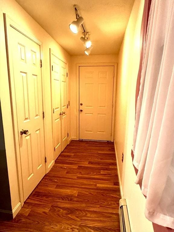 doorway to outside with a baseboard heating unit, track lighting, and dark hardwood / wood-style floors