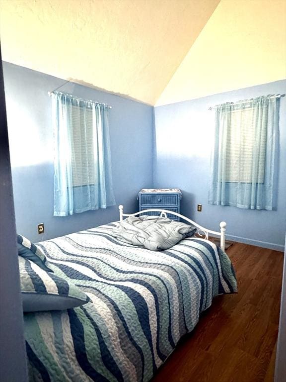 bedroom featuring vaulted ceiling, dark hardwood / wood-style floors, and a wall mounted AC