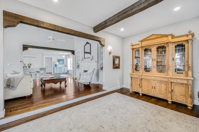 interior space with dark wood-type flooring, recessed lighting, beamed ceiling, and baseboards