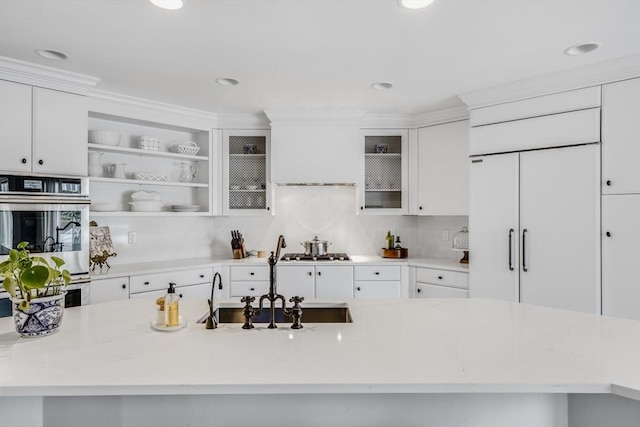 kitchen with white cabinets, a kitchen island with sink, stainless steel appliances, and a sink