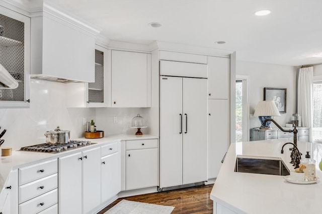 kitchen featuring dark wood finished floors, light countertops, stainless steel gas cooktop, and paneled built in refrigerator