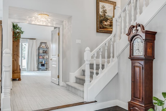 stairway featuring carpet floors and baseboards