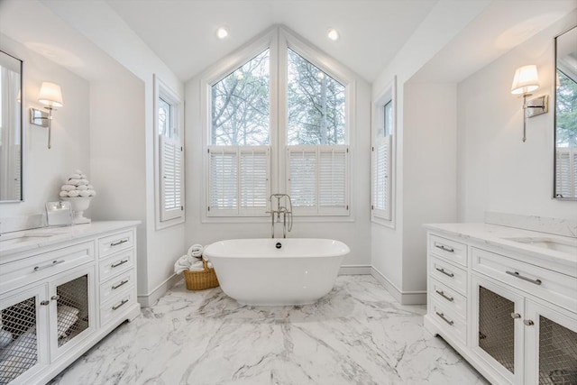 bathroom featuring a freestanding tub, vanity, baseboards, and marble finish floor