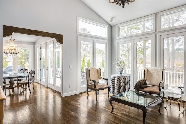 sunroom with vaulted ceiling, plenty of natural light, and an inviting chandelier