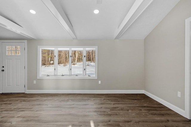 empty room with lofted ceiling with beams, recessed lighting, wood finished floors, and baseboards