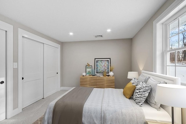 carpeted bedroom with a closet, visible vents, recessed lighting, and baseboards