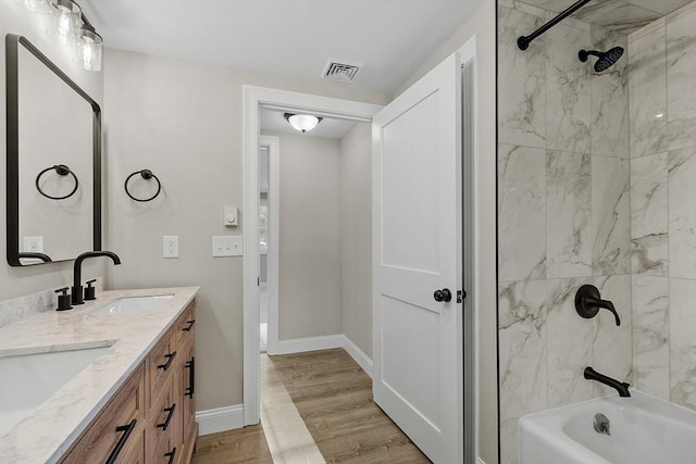 full bathroom with visible vents, wood finished floors, shower / bathtub combination, and a sink