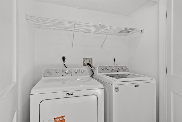 clothes washing area featuring laundry area and washer and clothes dryer