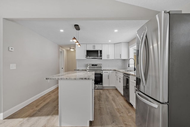 kitchen with light wood finished floors, a center island, decorative backsplash, stainless steel appliances, and a sink