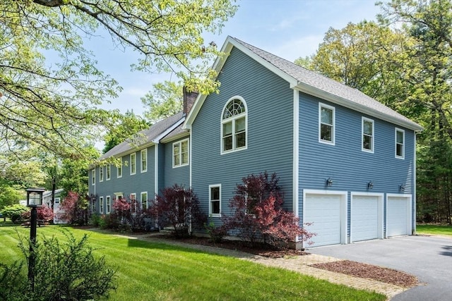 view of side of property with a lawn and a garage