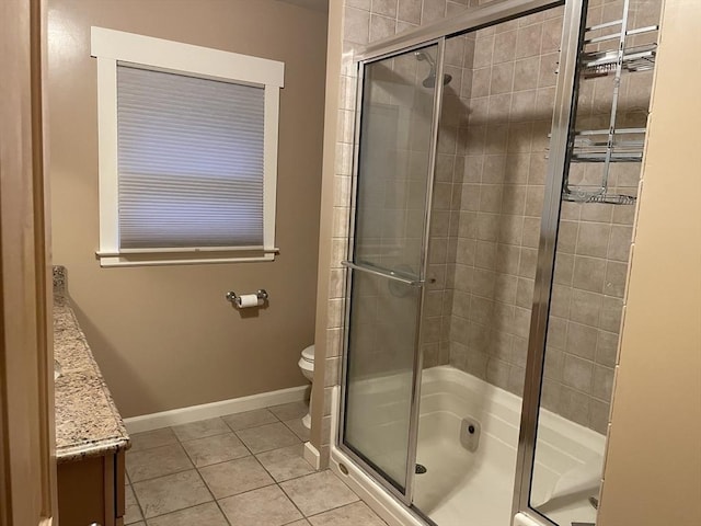 bathroom featuring toilet, vanity, tile patterned floors, and a shower with shower door