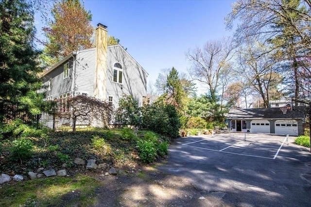 view of property exterior with fence and a chimney