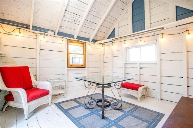 interior space featuring lofted ceiling with beams, wooden walls, and wooden ceiling