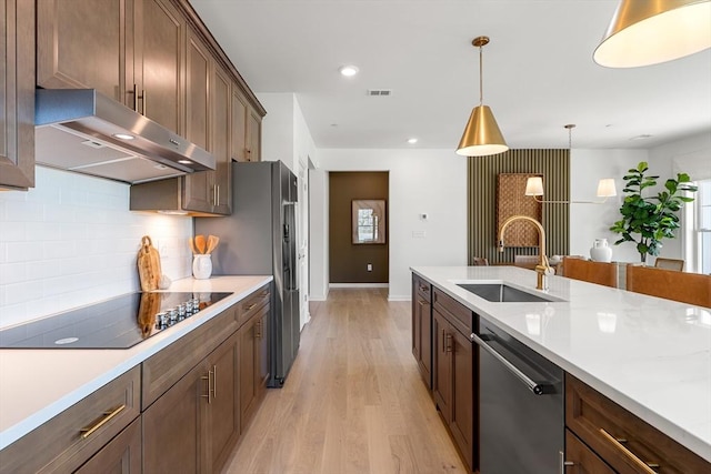 320 Martins Lndg Unit 307, North Reading, MA 01864 - kitchen featuring dishwasher, under cabinet range hood, a sink, black electric stovetop, and light wood-style floors