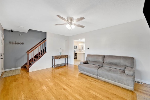 living room with ceiling fan and wood-type flooring