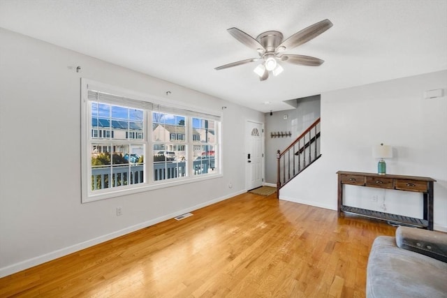 living room with ceiling fan and light wood-type flooring