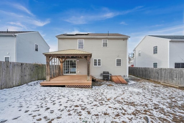 snow covered back of property featuring cooling unit, a deck, and a gazebo