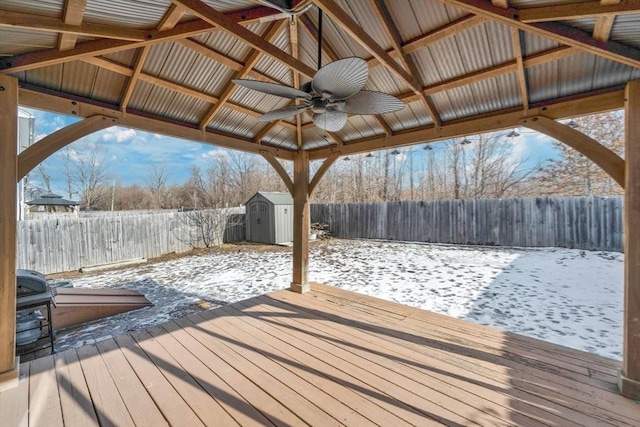 snow covered deck with a gazebo, ceiling fan, and a storage unit