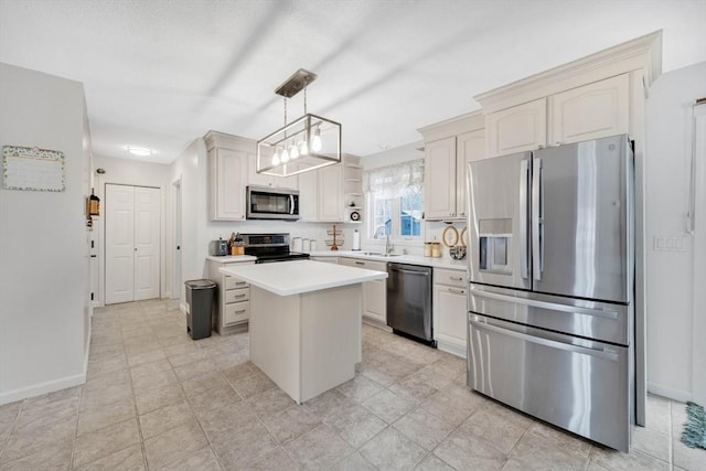 kitchen featuring sink, stainless steel appliances, white cabinets, a kitchen island, and decorative light fixtures