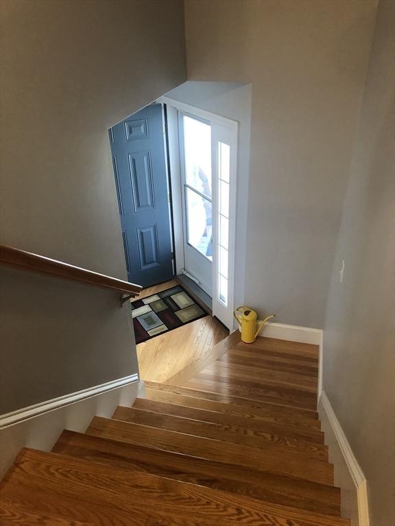 interior space with baseboards, wood finished floors, and stairway