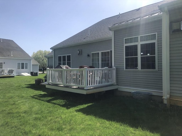 back of property with a lawn, a wooden deck, and cooling unit