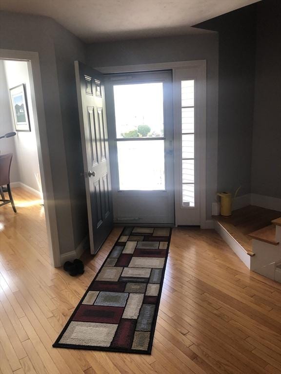 doorway to outside with baseboards and light wood finished floors