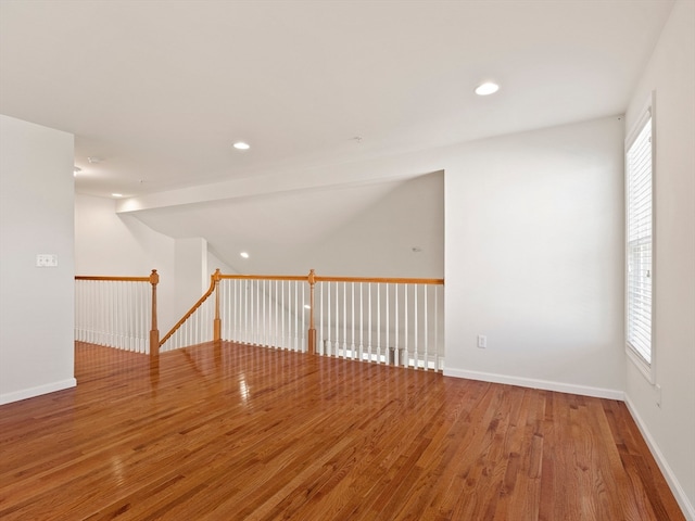 spare room with wood-type flooring and a healthy amount of sunlight