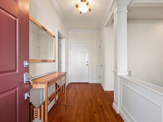 foyer entrance featuring crown molding, dark wood-type flooring, and decorative columns